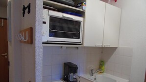 A compact kitchenette with a microwave, coffee maker, and a sink. - 3rd floor, view valley, balcony, tv, ski locker, 19m², Valfréjus (Valfréjus)