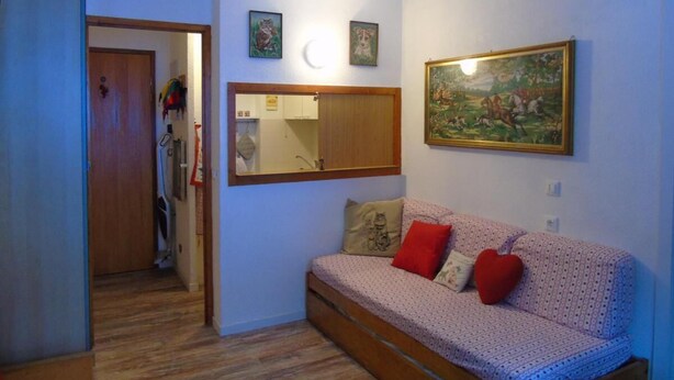 Une pièce chaleureuse avec un canapé à motifs, un miroir et un tableau accroché au mur.