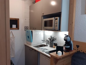A compact kitchen with a microwave, coffee machine, and a sink. - 20m from shops, 2nd floor, balcony, tv, ski locker, 19m², Valfréjus (Valfréjus)