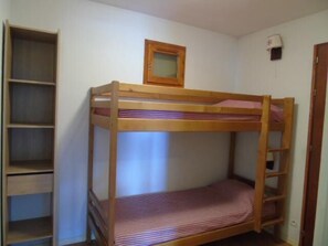 A bunk bed with a wooden frame, a small window, and a shelf unit to the left. - 1st floor, view valley, balcony, tv, ski locker, 48m², Valfréjus (Valfréjus)