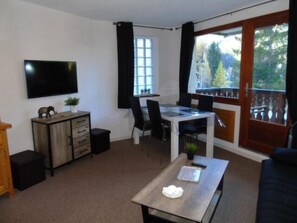 A living room with a TV, a dining table, and a sofa. - 1st floor, balcony, tv, ski locker, 29m², Valfréjus (Valfréjus)