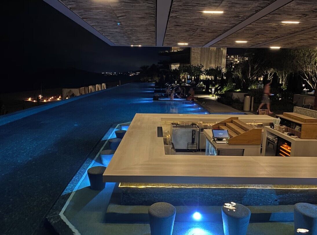 A modern pool area with a bar and seating.