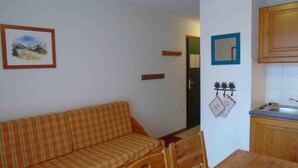 A small room with a sofa, a dining table, and a kitchen area. - Ground floor, view valley, tv, ski locker, 31m², Valfréjus (Valfréjus)