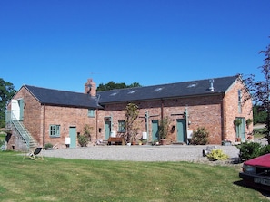 Traditional brick building with a central entrance and sloped roof.