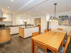 Enjoy meals in the kitchen with a stove and dining area featuring a wooden table.