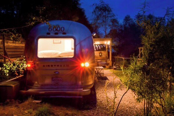 Una caravana con el número 6000 estacionada en un jardín de noche.