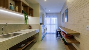 A modern kitchen with a granite countertop, a built-in sink, and wooden shelves. - Get a Flat 1905 - Brooklin (São Paulo)