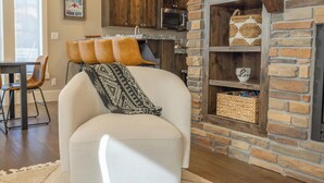 Una sala de estar con sofá, chimenea y área de cocina al fondo.