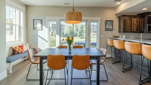 Una cocina moderna con comedor, ventanas amplias y vistas al exterior.
