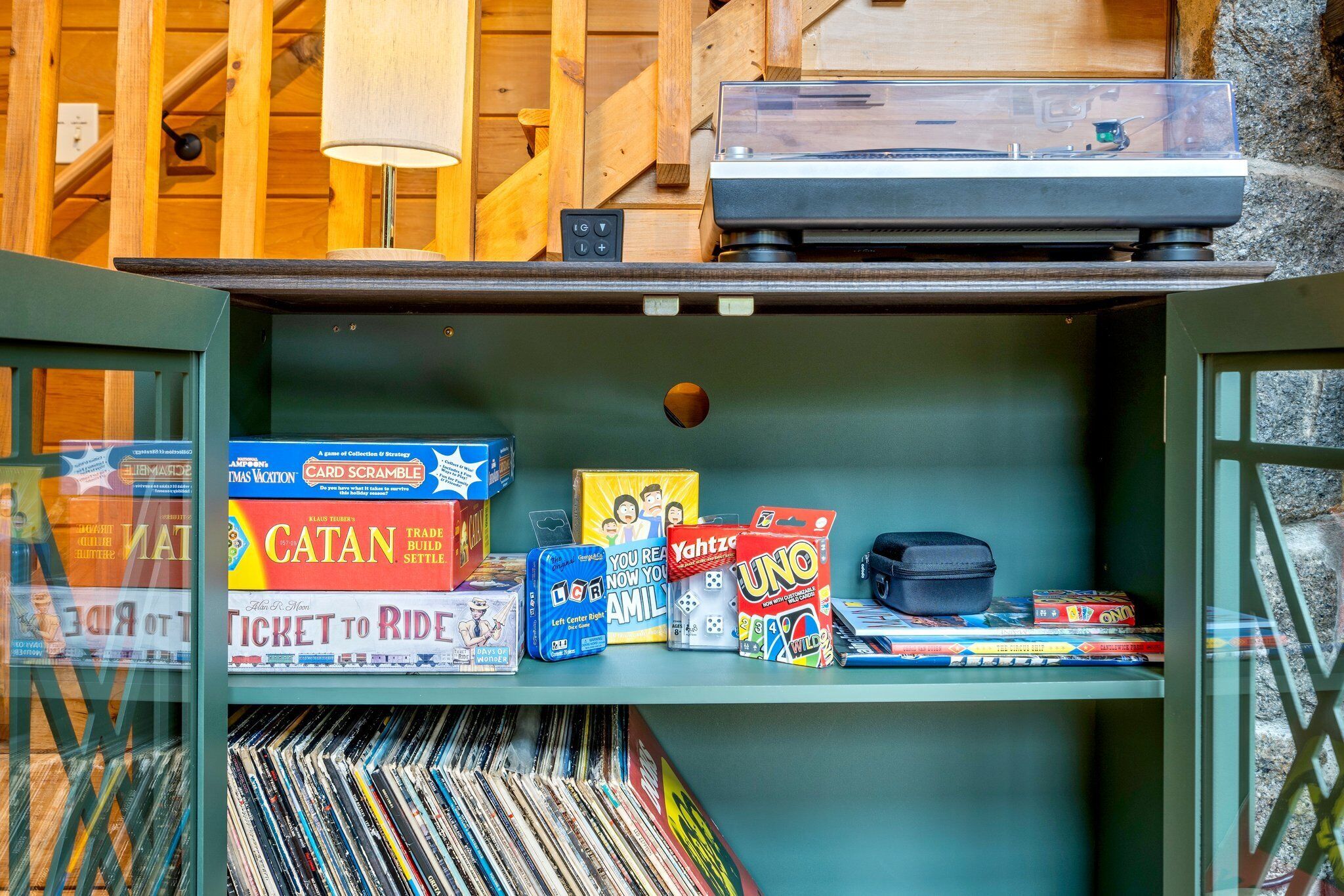 A room with a wooden interior, a record player, and various board games on shelves.