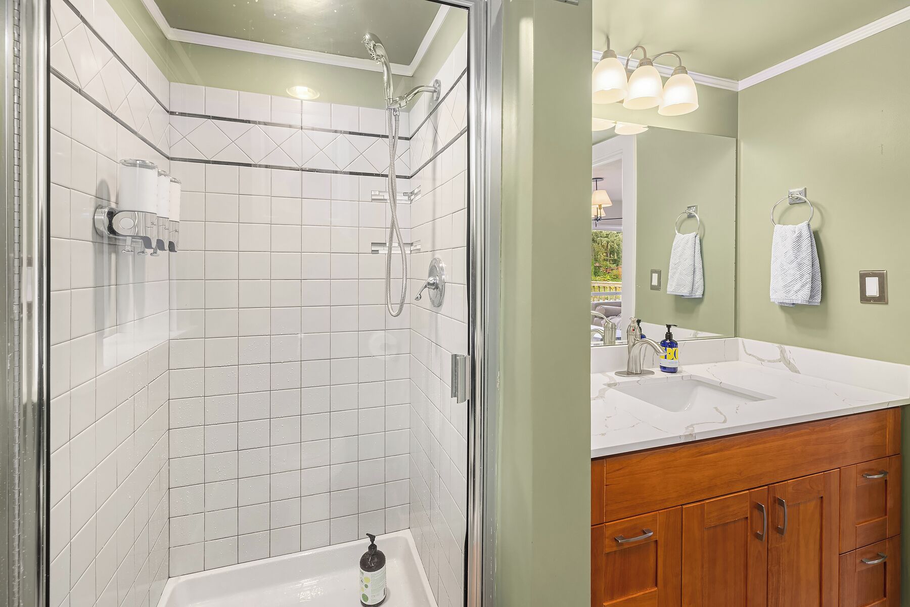 Une salle de bain avec une douche, un lavabo et des meubles en bois.