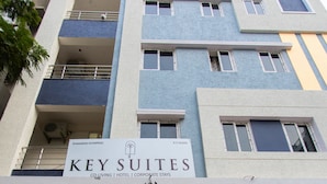 A hotel entrance with a sign reading "KEY SUITES" and a modern architectural design.