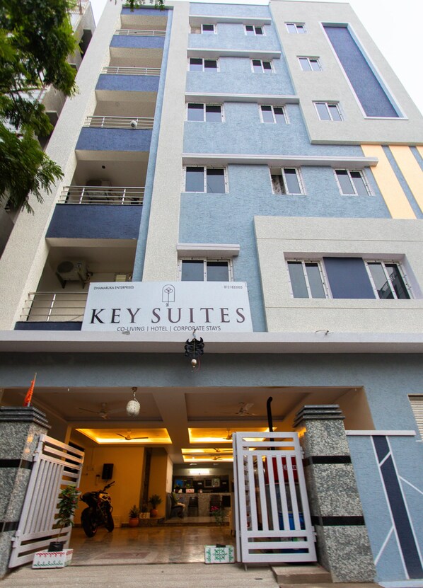 L’entrée d’un hôtel, avec une enseigne indiquant « KEY SUITES » et une architecture moderne.