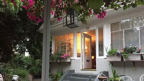 A house with a covered porch, a wooden table, and chairs. - Vintage Cottage steps from Venice Beach (Los Angeles)