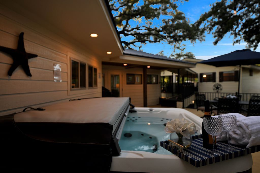 Een wellnessruimte met een jacuzzi, decoratie van zeesterren en een fles champagne.