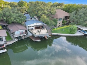 Une propriété au bord du lac, dotée d’un quai, d’une terrasse couverte et d’un bâtiment en pierre.