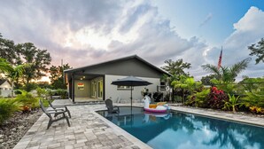 A modern house with a swimming pool, outdoor seating, and lush landscaping. - Inspiration House-One Acre Pool Home in the Heart of Pinellas!  (Pinellas Park)