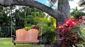 A wooden bench under a large tree with a swing hanging from its branches. - Inspiration House-One Acre Pool Home in the Heart of Pinellas!  (Pinellas Park)