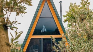 A modern, triangular-shaped building with large windows and a wooden deck. - KARMATTE BUNGALOW  (Kartepe)