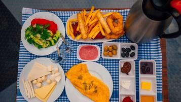 Bandeja de comida con papas fritas, queso y una tortilla, junto con salsas y aceitunas.
