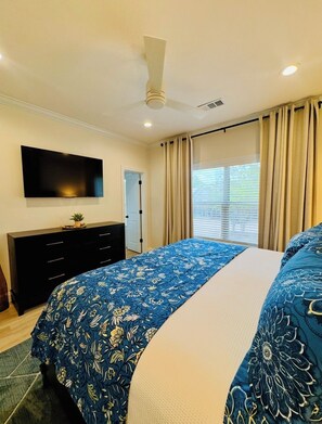 A bedroom with a bed, a TV, a ceiling fan, and a window with curtains. - Luxury, Location & Southern Hospitality—1 Mile to Ole Miss & The Square (Oxford)