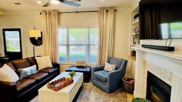 TV connectée, cheminée, livres, chaîne hi-fi