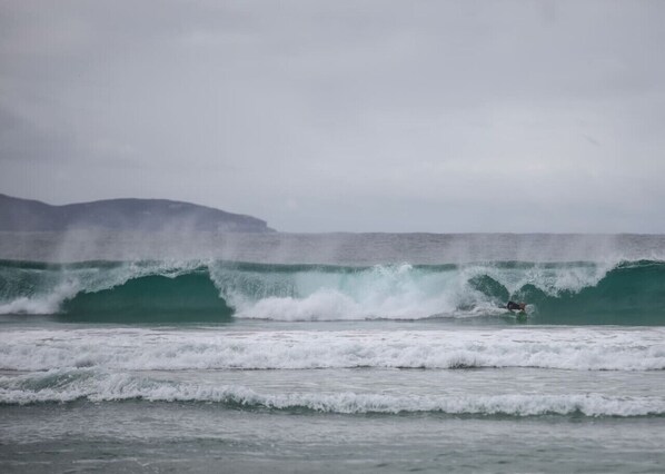 A surfer riding a large wave in the ocean.
