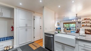 A modern kitchen with white cabinets, a dishwasher, and a large island with a sink. - Walk to Lake, Dining+shops 5mins to Ski Resort Incline Paradise by Avantstay (Incline Village)