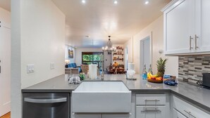 A modern kitchen with a central island, stainless steel appliances, and a view to the dining area. - Walk to Lake, Dining+shops 5mins to Ski Resort Incline Paradise by Avantstay (Incline Village)