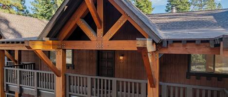 Una cabaña de madera con un balcón, una puerta con el número 23 y una ventana.