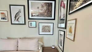 Une chambre à coucher avec un lit, une table de chevet et un mur orné de tableaux.
