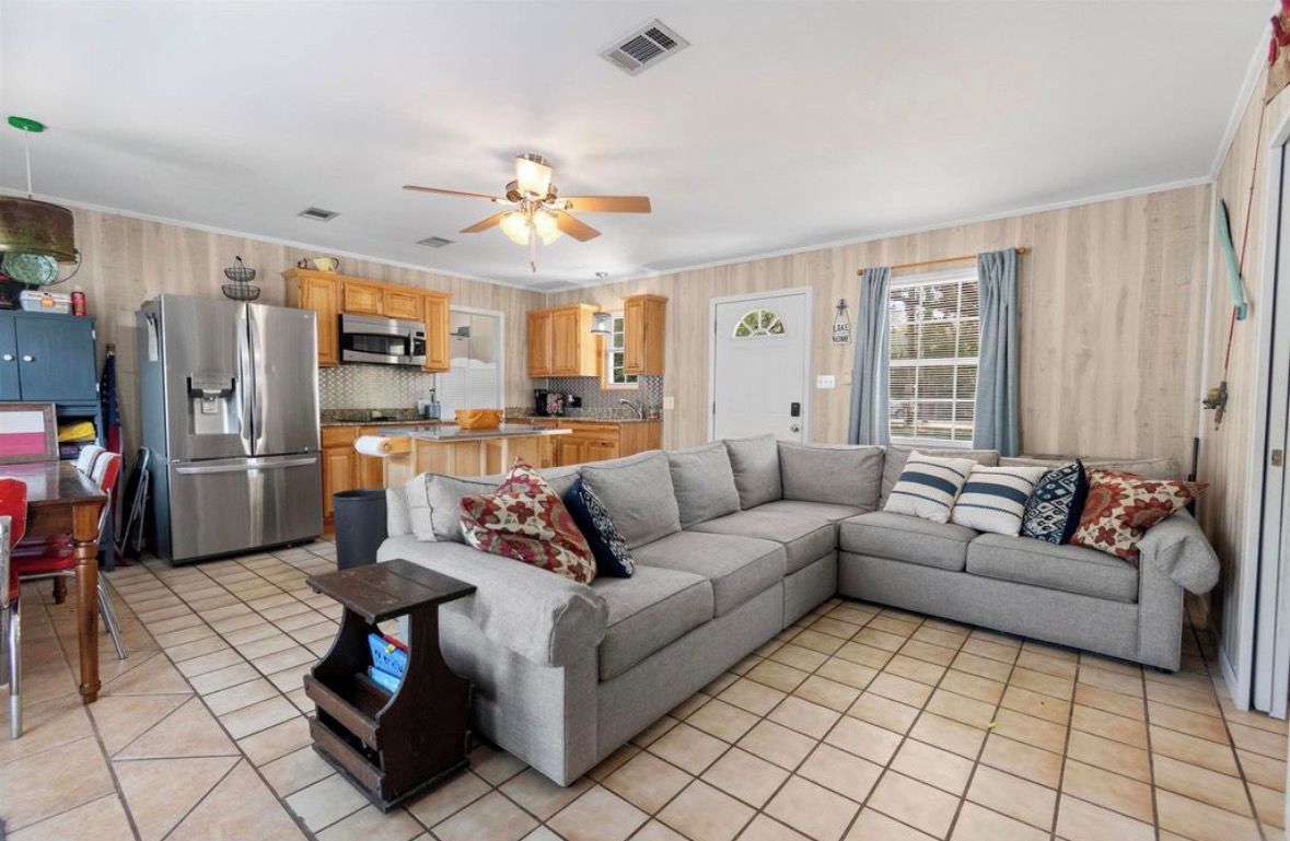 A modern kitchen with a refrigerator, microwave, and wooden cabinets.