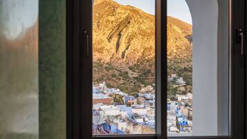 A window with a view of a mountainous landscape and a town below.