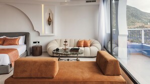 Un dormitorio moderno con una cama grande, un sofá, una mesita de centro y vistas al exterior.