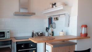 Una cucina compatta con forno a microonde, forno e isola in legno.