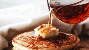 A stack of pancakes with syrup being poured on top. - Lavender Hill Bed & Breakfast (Athens)