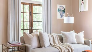 A cozy living room with a sofa, a coffee table, and a side table with books. - Lavender Hill Bed & Breakfast (Athens)
