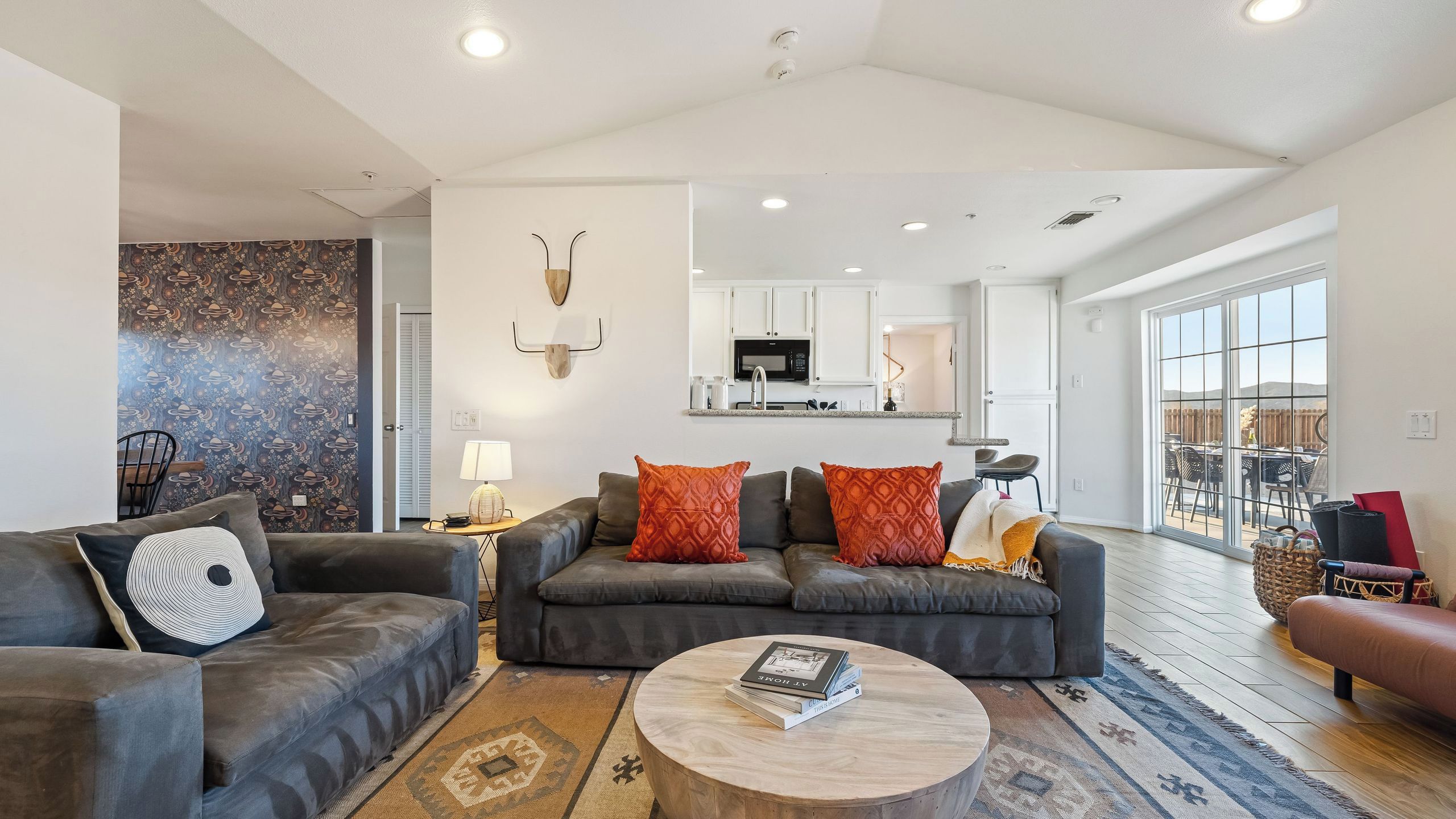 A modern living room with a sofa set, a coffee table, and a patterned rug.