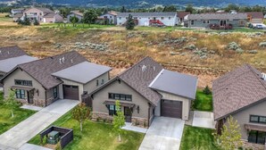Et boligområde med huse i moderne arkitektur, velholdt græsplæne og et bjergrigt bagland.