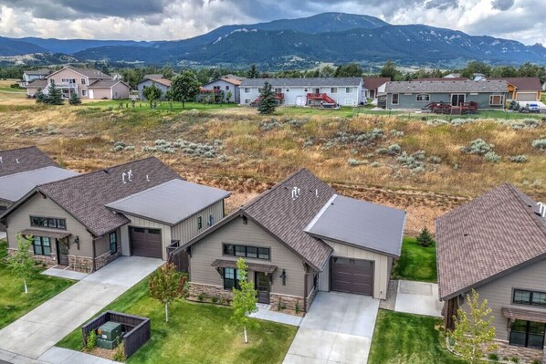 A residential area with houses featuring modern architecture, a well-maintained lawn, and a mountainous backdrop. - 13 Alpine Basin Loop (Red Lodge)