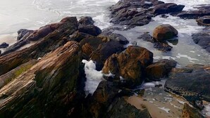 Una costa rocosa con olas rompiendo contra las rocas.