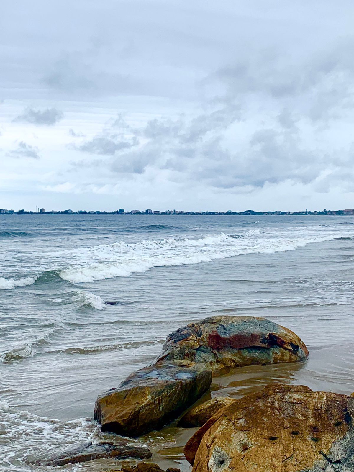 A beach with large rocks and waves.