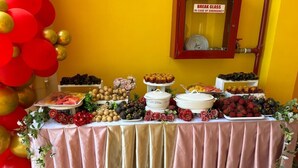 Une table de buffet garnie de divers aliments, avec une pancarte indiquant : « EN CAS D’URGENCE, CASSER LA VITRE ».