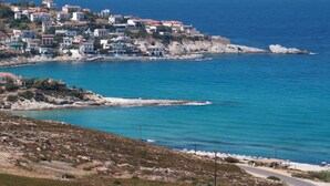 A coastal town with buildings on a hillside overlooking the sea. - Ikaros Star Hotel (Ikaria)