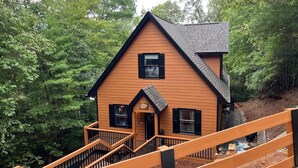A wooden cabin with a steep staircase leading to the entrance, surrounded by dense forest. - Helen Haus, Sleeps 10, Fire Pit / Pool Table! Golf (Helen)
