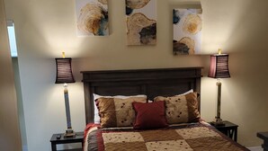 A bedroom with a large bed, two bedside tables, a nightstand, and three wall-mounted lamps. - Luxury 1 bedroom, 1 Bath apt. in the middle of downtown Detroit w/parking spot!  (Detroit)