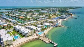 A coastal resort with multiple buildings, a marina, and a beach.
