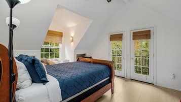 Un dormitorio con cama, lámpara de pie y ventilador de techo.