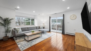 A modern living room with a sectional sofa, a coffee table, and a TV on a stand.