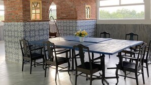 Comedor con pared de ladrillo, baldosas estampadas y un ventanal grande.